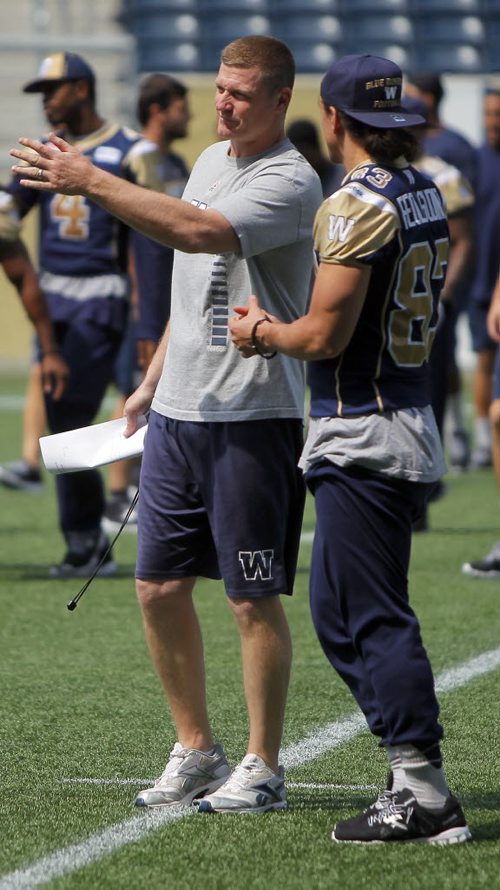 WINNIPEG BLUE BOMBERS WALK THROUGH PRACTICE AT THE STADIUM. Coach O'Shea talks to Julian Feoli-Gudino. BORIS MINKEVICH/WINNIPEG FREE PRESS July 9, 2015