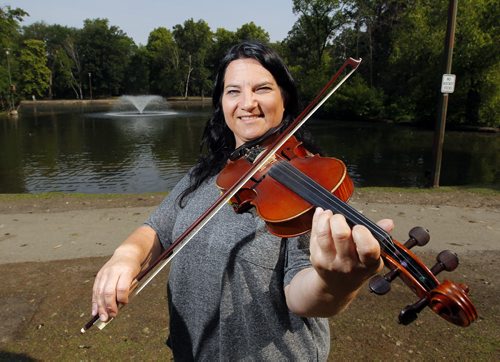 Patti Kusturok and her fiddle for story on her 365 days of fiddle project. Photo taken at St. Vital Park Duck Pond Pavilion. BORIS MINKEVICH/WINNIPEG FREE PRESS July 9, 2015