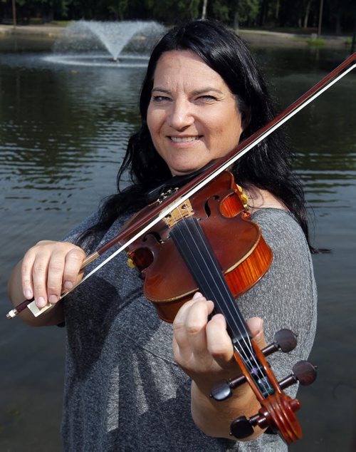 Patti Kusturok and her fiddle for story on her 365 days of fiddle project. Photo taken at St. Vital Park Duck Pond Pavilion. BORIS MINKEVICH/WINNIPEG FREE PRESS July 9, 2015