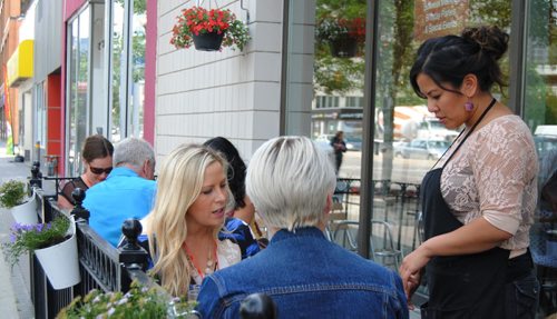 Co-owner of Casa Burrito, Valerie Bermudez, (right) explains a dish to patrons on her new patio. (Jessica Botelho-Urbanski / Winnipeg Free Press)