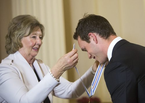 Jonathan Toews bends down to be presented with his medal while being awarded the Order of Manitoba at the Manitoba Legislative Building in Winnipeg on Thursday, July 9, 2015.   Mikaela MacKenzie / Winnipeg Free Press