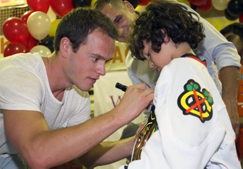 Chicago Blackhawks star Jonathan Toews, gives youngster Trevi Tawletz a autograph at Old Exhibition Arena- He made a visit as a ambassador to the Nourishing Potential grants project that helps thousands of Winnipeg Kids . Toews will join 11 others late this afternoon at the Manitoba Legislature to receive the Order of Manitoba -See story- July 09, 2015   (JOE BRYKSA / WINNIPEG FREE PRESS)