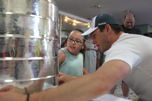 The Chicago Blackhawks captain and Stanley Cup champion, Jonathan Toews points out his name on 2015 Stanley Cup to one of the children from the Rehabilitation Centre for Children  during a visit to the centre Friday.   July 10, 2015 n Ruth Bonneville / Winnipeg Free Press