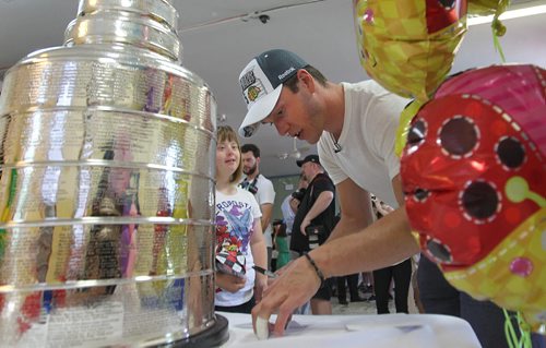The Chicago Blackhawks captain and Stanley Cup champion, Jonathan Toews signs his autograph on a photo for Jamie Yeo next to the 2015 Stanley Cup during a  visit to  the Rehabilitation Centre for Children at 633 Wellington Crescent Friday.  July 10, 2015 n Ruth Bonneville / Winnipeg Free Press