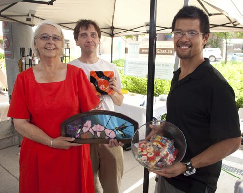 Unique products, baking and produce are available at the outdoor Downtown Farmers Market at Manitoba Hydro Place. The market, organized by Downtown Winnipeg BIZ, is open from 10 a.m. to 3 p.m. every Thursday during the summer months, until mid-September. It then reverts to a monthly event indoors. Pictured, from left, are Kathy Bell, Joseph Dyer (kbglass.ca) and Jeff Poon (sweetcbakery.ca). (John Johnston / Winnipeg Free Press)