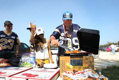Tail Gating- Jennifer Downing and John Couture prepare some hotdogs in parking lot outside Investors Group Field Friday before the game between the Montreal Alouettes and the Winnipeg Blue Bombers- Standup Photo- July 10, 2015   (JOE BRYKSA / WINNIPEG FREE PRESS)