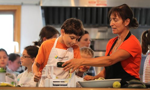 Sunday This city piece on the Food Studio, Maria Abiuis (orange shirt), owner of The Food Studio hosts cooking camps during the summer for kids & teens with the help of her sister Angela Houldsworth (grey shirt). Ari Kay  cuts zucchini into spirals with the help of Maria while kids look on during class.  See Dave Sanderson story.  July 09, 2015 Ruth Bonneville / Winnipeg Free Press