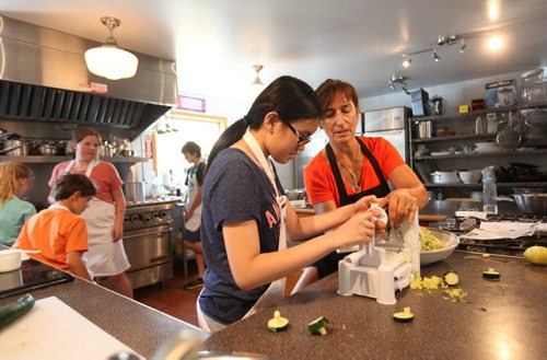 Sunday This city piece on the Food Studio, Maria Abiuis (orange shirt), owner of The Food Studio hosts cooking camps during the summer for kids & teens with the help of her sister Angela Houldsworth (grey shirt). Carrington Dong gets help from Maria during class.  See Dave Sanderson story.  July 09, 2015 Ruth Bonneville / Winnipeg Free Press