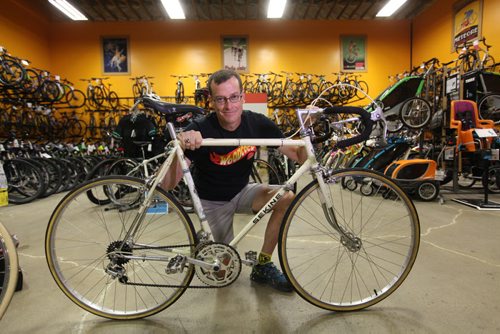 Tim Woodcock, owner of Woodcock Cycle next to  a Sekine bike from the 80's in his shop.  Secondary art of the bike and a collection of bike badges (those metal pieces that are affixed to the handlebars) and he has  from vintage Sekine bikes for story by Dave Sanderson.  July 09, 2015 Ruth Bonneville / Winnipeg Free Press
