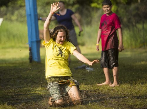 Emily McDougal, councillor at the West Broadway Youth Outreach Program, slides down the mud from the showers at the Winnipeg Folk Festival in Birds Hill Park on Friday, July 10, 2015.   Mikaela MacKenzie / Winnipeg Free Press