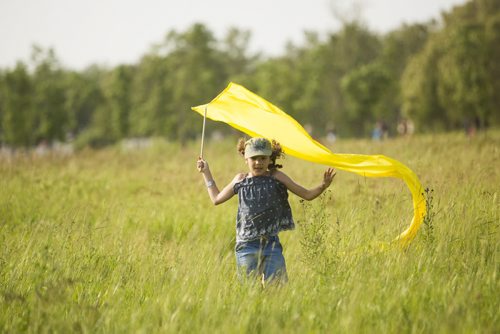 Leah MacKinnon runs through a field with a ribbon at the Winnipeg Folk Festival in Birds Hill Park on Friday, July 10, 2015.   Mikaela MacKenzie / Winnipeg Free Press
