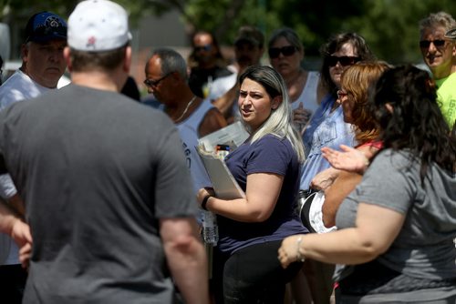 Connie Muscat, blue shirt with papers, helping organize friends and neighbours as they search for Thelma Krull in East Kildonan, Sunday, July 12, 2015. (TREVOR HAGAN/WINNIPEG FREE PRESS)
