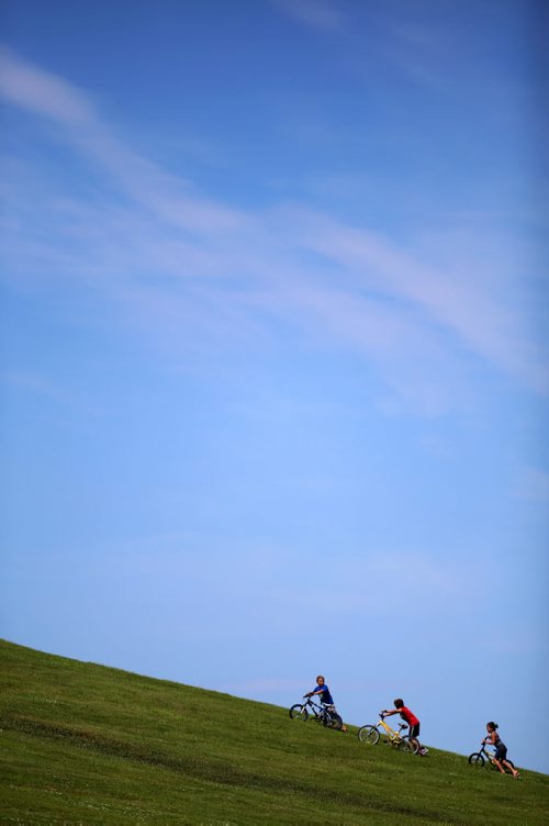 Three kids push their bikes up a hill in Civic Park, Sunday, July 12, 2015. (TREVOR HAGAN/WINNIPEG FREE PRESS)