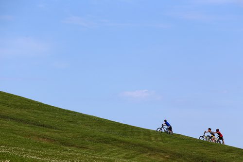 Three kids push their bikes up a hill in Civic Park, Sunday, July 12, 2015. (TREVOR HAGAN/WINNIPEG FREE PRESS)