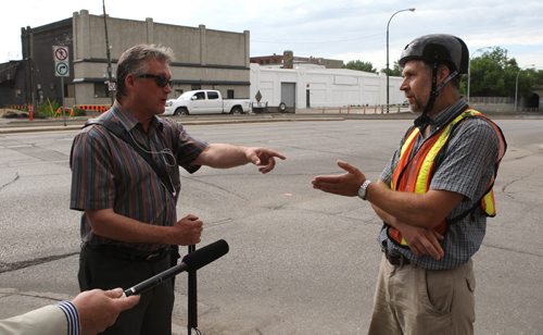 Ross Eadie (left) got into a debate with John Wilmot of the North Winnipeg Commuter Cyclists group during a media event Monday. BORIS MINKEVICH/WINNIPEG FREE PRESS July 13, 2015