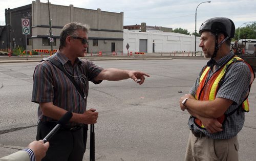 Ross Eadie (left) got into a debate with John Wilmot of the North Winnipeg Commuter Cyclists group during a media event Monday. BORIS MINKEVICH/WINNIPEG FREE PRESS July 13, 2015