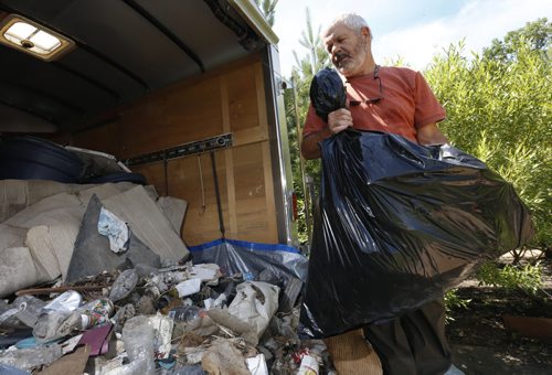 Bill Fisher with some of the trash recently collected along the Perimeter Highway near Brady Rd. He will haul it to the dump.  Gord Sinclair story. Wayne Glowacki / Winnipeg Free Press July 13 2015