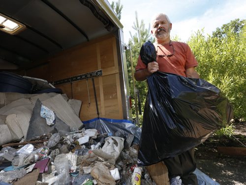 Bill Fisher with some of the trash recently collected along the Perimeter Highway near Brady Rd. He will haul it to the dump.  Gord Sinclair story. Wayne Glowacki / Winnipeg Free Press July 13 2015