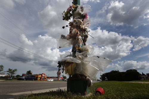 July 12, 2015 - 150712  -  On Monday, July 13, 2015 dead and artificial flowers hang from this lamp post on Keewatin at Burrows where Gloria Davey was killed when she was hit by a city bus.  John Woods / Winnipeg Free Press