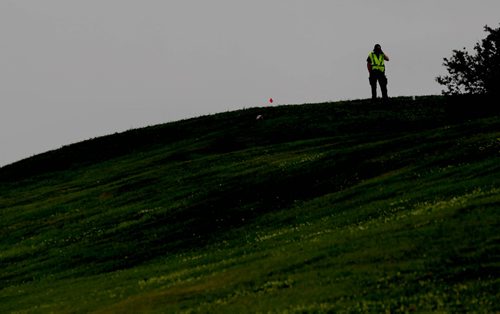 A police officer searches at the top of the hill near Valley Garden's CC for the  missing women, Thelma Krull, Tuesday.  July 14,, 2015 Ruth Bonneville / Winnipeg Free Press