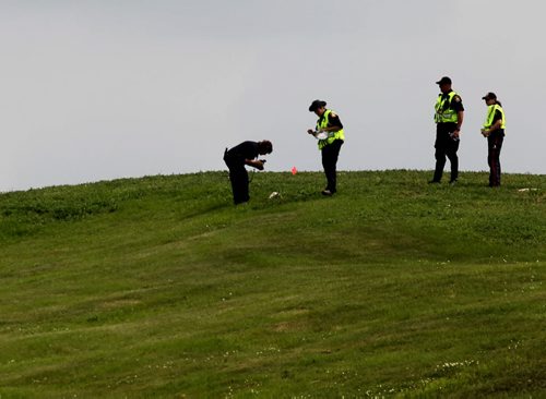 A Police officer takes a photo of a suspicious  item  at the top of Kimberly hill where members of the police and cadet units  search for missing women Thelma Krull in the area around Valley Gardens CC Tuesday.  July 14,, 2015 Ruth Bonneville / Winnipeg Free Press