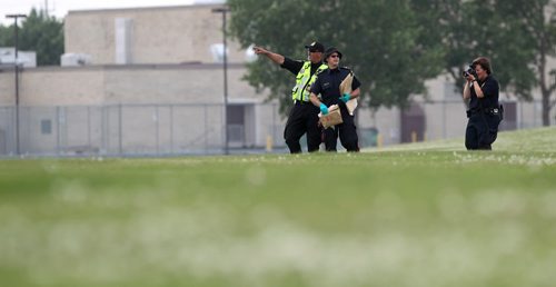 Officers carry bags of suspicious items or evidence in paper bags after being photographed in the field adjacent to Kimberly Hill  near Valley Gardens CC Tuesday where police and cadet units have been searching for the missing women, Thelma Krull.  July 14,, 2015 Ruth Bonneville / Winnipeg Free Press