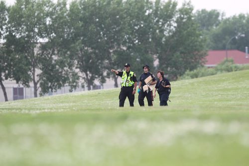 Officers carry bags of suspicious items or evidence in paper bags after being photographed in the field adjacent to Kimberly Hill  near Valley Gardens CC Tuesday where police and cadet units have been searching for the missing women, Thelma Krull.  July 14,, 2015 Ruth Bonneville / Winnipeg Free Press