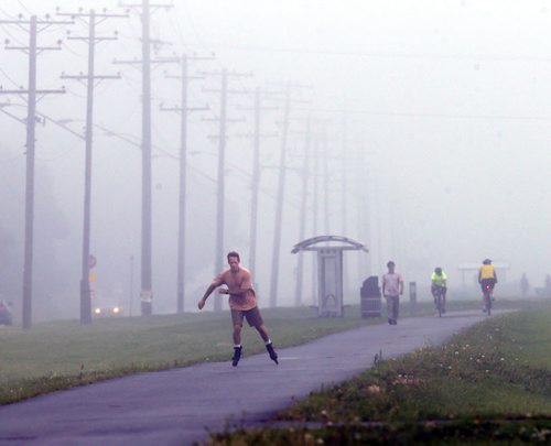 Cam Bell glides through the fog with rollerblades on the Northeast Pioneers Greenway along Gateway Rd. Wednesday morning.  Weather story. Wayne Glowacki / Winnipeg Free Press July 15 2015