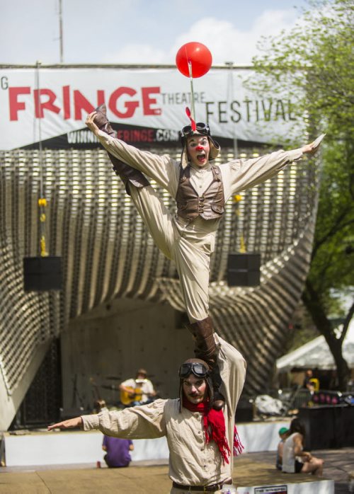 Amica Hunter stands on David Cantor's shoulders, promoting their show Beau & Aero, at the Winnipeg Fringe Festival kick-off at the Old Market Square in Winnipeg on Wednesday, July 15, 2015.   Mikaela MacKenzie / Winnipeg Free Press