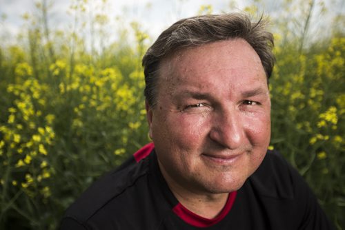 Doug Chorney, East Selkirk farmer, in his canola fields on Wednesday, July 15, 2015.  The haze has created optimal conditions for growing, and Manitoba is looking forward to a bumper harvest this year.   Mikaela MacKenzie / Winnipeg Free Press