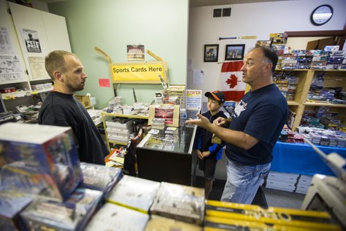 Mike Bergmann (left), owner of Lower Level Sports Cards and Collectibles, chats with customers Rob and Mathiew Ferrand in his sports card shop in Elmwood on Thursday, July 16, 2015.  Mikaela MacKenzie / Winnipeg Free Press