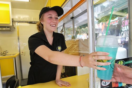 Sam Ward-Gottfredsen  from the Lemon Heaven food truck hands over one of their drinks to a customer. Many food trucks surround Old Market Square in the Exchange District during the Fringe Festival Thursday afternoon.  150716 July 16, 2015 MIKE DEAL / WINNIPEG FREE PRESS