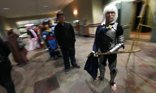 Elijah Reyes stands ready as Kamui from the show Fire Emblem Fates as he waits in line to register and join thousands of Anime fanss Friday morning. See release below. July 17, 2015 - (Phil Hossack / Winnipeg Free Press)  Ai-Kon, Manitoba's largest Japanese animation (anime) and Asian culture, convention will be held on July 17-19th at the RBC Convention Centre; the event runs around the clock from 12:00 pm on Friday, July 17, 2015 through to 4:00 pm on Sunday, July 19th, 2015. This year marks Ai-Kon's 14th year, bringing over a decade of their anime conventions to the city of Winnipeg. What started out as an event with only 500 in attendance, has grown to over 3000 people who attend annually. Those in attendance take part in the weekend's various festivities such as costume contests, video games, anime showings and various panels relating  to anime and Japanese culture. Attendees also get a chance to meet special guests working in the industry and ask them questions about their experiences. This year Ai-Kon will be welcoming the following guests: Eric Vale (Voice Actor), The 404s (Canadian Geek Improv Team), Greg Ayres (Voice Actor and DJ), Vickybunnyangel Cosplayer (Professional Canadian Cosplayer), Terri Hawkes (Voice Actress) and Ian Sinclair  (Voice Actor). Specific roles and guest information can be viewed at  http://www.ai-kon.org/guests. Ai-Kon (http://www.ai-kon.org) is Manitoba's largest anime convention. An all-ages event, the goal of Ai-Kon is the promotion of Japanese/Asian animation and culture to the public. Started in 2001 by a local anime club, Ai-Kon took a reorganizing hiatus in 2002. It returned in 2003 to become an autonomous event, run by an independent volunteer committee. "Ai" means "love" in Japanese, hence Ai-Kon's slogan "For the Love of Anime".