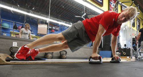 Trainer Richard Burr demonstrates the lateral abdominal slide exercise at the Richard Burr Fitness Friday.  Scott Billeck  story Wayne Glowacki / Winnipeg Free Press July 17 2015