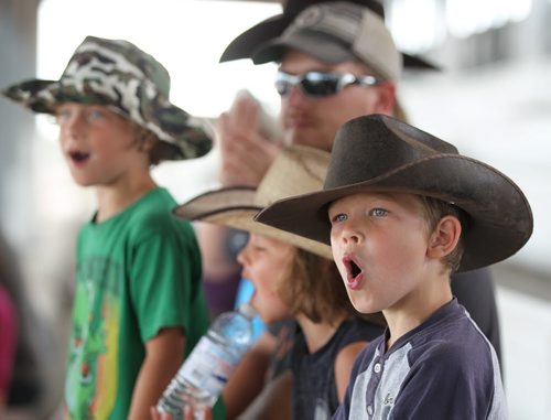 Five-year-old Brady Klassen (right) and his family watch the first of the chariot races make their way around the track at the Morris Grandstand during the 52nd annual Morris Stampede Friday afternoon.   July 16,, 2015 Ruth Bonneville / Winnipeg Free Press