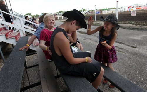 Brett Saindon goofs around with his little sister Shaelyn  11yrs between  horse races at the Morris Grandstand during the 52nd annual Morris Stampede Friday afternoon.   July 16,, 2015 Ruth Bonneville / Winnipeg Free Press