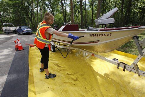 July 19, 2015 - 150719  -  Kaela Lowey, watercraft inspector with the Manitoba Conservation Aquatic Invasive Species program, washes boats coming out of the Red River at St. Vital Park Sunday July 19, 2015.  John Woods / Winnipeg Free Press