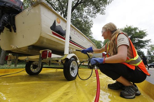 July 19, 2015 - 150719  -  Kaela Lowey, watercraft inspector with the Manitoba Conservation Aquatic Invasive Species program, washes boats coming out of the Red River at St. Vital Park Sunday July 19, 2015.  John Woods / Winnipeg Free Press