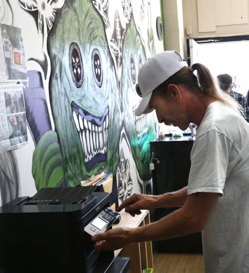 Glenn Price runs the photo copier Tuesday morning at his shop, Your Medical Cannabis Headquarters and began selling medical marijuana again despite a police order last Tuesday to stop.  Aidan Geary story Wayne Glowacki / Winnipeg Free Press July 21 2015