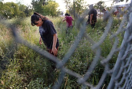 Indigenous searchers are scouring the fields in Elmwood and all of its walkways for clues to the strange disappearance of Thelma Krull, who vanished on a morning walk 11 days ago. "Well keep on going as long as searchers come out," said organizer Kim Ricker (centre) as she leads a group through industrial wastelands along Raleigh street Wednesday evening. See Alex Paul's story. July 22, 2015 - (Phil Hossack / Winnipeg Free Press)