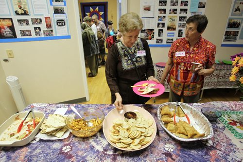 Mary Omar (left) and Laura Chebib (right) at the Islamic Social Services Association which held an open house and feast with food from around the world in its new offices Thursday evening to celebrate Eid, marking the end of Ramadan (Muslim fasting month).   150723 July 23, 2015 MIKE DEAL / WINNIPEG FREE PRESS