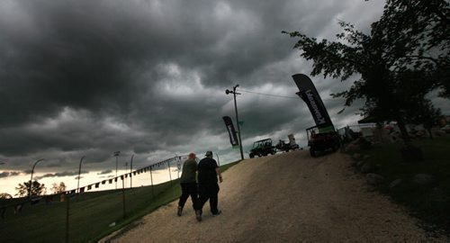 Ignoring the sky a pair of race fans ascends the hill towards the fan seating at Red River Raceway Thursday evening. Racers prepped under the looming weather and got one race in before the sky opened up and cancelled the races till Monday night. July 23, 2015 - (Phil Hossack / Winnipeg Free Press)
