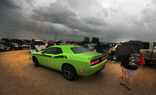Race fans make their way through a downpour to the parking lot and home at Red River Raceway Thursday evening. Racers prepped under the looming weather and got one race in before the sky opened up and cancelled the races till Monday night. July 23, 2015 - (Phil Hossack / Winnipeg Free Press)