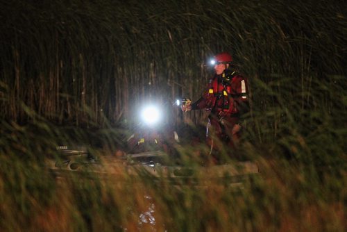 Winnipeg Fire Paramedic Water Rescue teams work their way around the retention pond located at the end of Kearney Street close to Beliveau Road after witnesses reported seeing at least one person in the water Thursday evening around 9:30pm.  150723 July 23, 2015 MIKE DEAL / WINNIPEG FREE PRESS