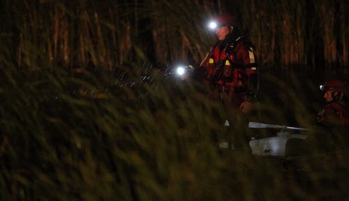 Winnipeg Fire Paramedic Water Rescue teams work their way around the retention pond located at the end of Kearney Street close to Beliveau Road after witnesses reported seeing at least one person in the water Thursday evening around 9:30pm.  150723 July 23, 2015 MIKE DEAL / WINNIPEG FREE PRESS