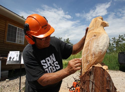 Russ Kubara displays his techniques on how to carve wood with a chainsaw at Tyndall Firewood Supply Ltd near Tyndall, Manitoba  - He teaches workshops in spring and fall- Kubra puts chalk lines on eagle that he is finishing-See David Sanderson story- July 23, 2015   (JOE BRYKSA / WINNIPEG FREE PRESS)
