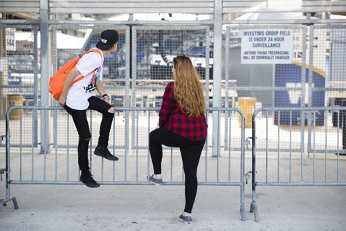 One direction fans Austin Klotz and Jessica Krotowich wait and look into the stadium four hours before the show at the Investors Group Field in Winnipeg on Friday, July 24, 2015.  Mikaela MacKenzie / Winnipeg Free Press
