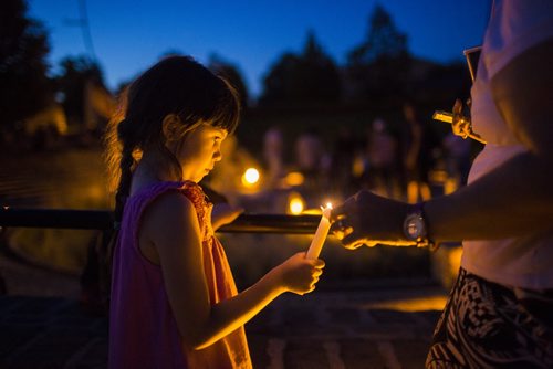 Annoula Pavlopoulou's mom helps light her candle at a candlelit vigil for all missing and murdered at the Forks in Winnipeg on Saturday, July 25, 2015.  Mikaela MacKenzie / Winnipeg Free Press