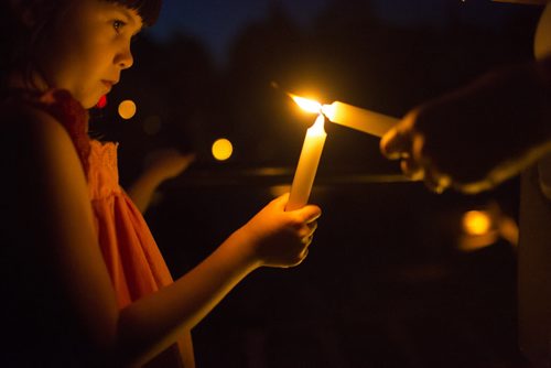 Annoula Pavlopoulou's mom helps light her candle at a candlelit vigil for all missing and murdered at the Forks in Winnipeg on Saturday, July 25, 2015.  Mikaela MacKenzie / Winnipeg Free Press