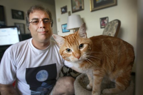 Frank Normand , a 47-year-old former long distance trucker on disability with his cat Tusk. Frank says landlord is trying to evict him because Tusk isnt the same cat he had when he signed the lease in 2003. Frank, and apparently his doctor who signed a note, considers the cat a caregiver and he says human rights likens it to a seeing-eye dog because of the comfort it brings is like medicine for Frank. -See story- July 27, 2015   (JOE BRYKSA / WINNIPEG FREE PRESS)